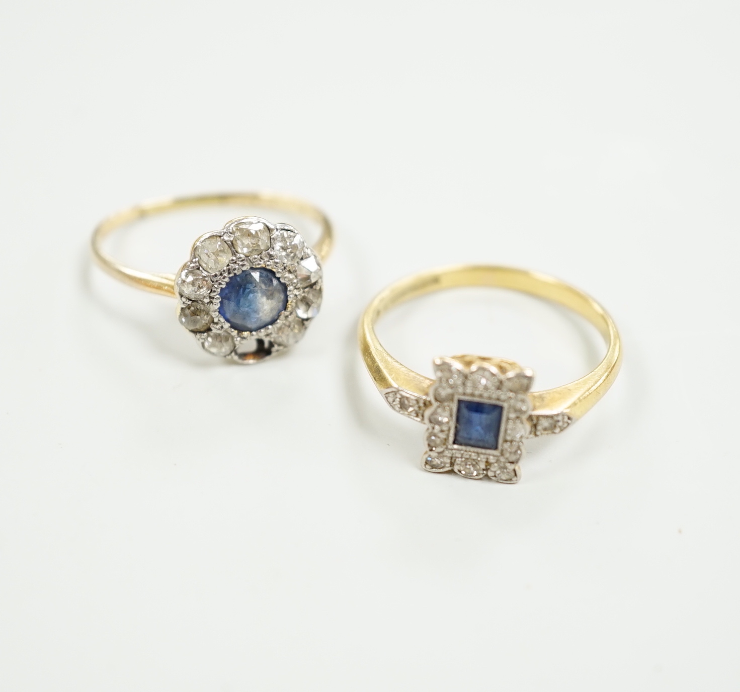 Two 1920's 18ct, sapphire and diamond cluster set dress rings, (one with misshapen shank and missing a diamond), gross weight 6.1 grams.